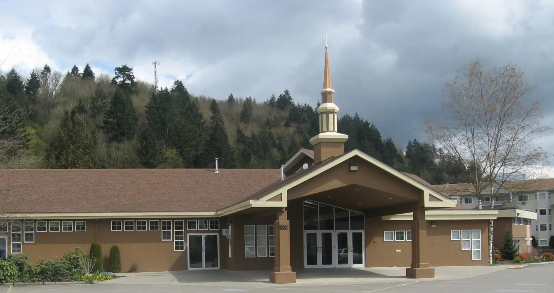 Cornerstone's church exterior and steeple beneath a cloudy sky